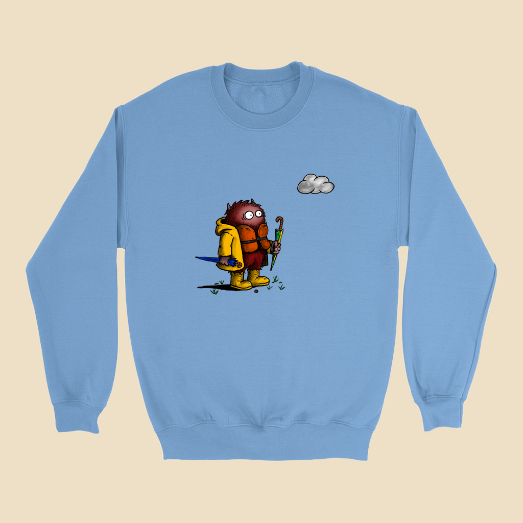 Sweatshirt featuring a cartoon creature wearing a raincoat, life jacket, and rain boots while carrying two umbrellas and staring nervously at a single cloud overhead.