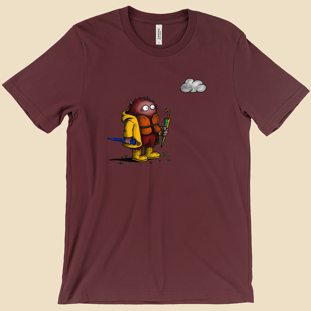 Abundance of Caution T-shirt featuring a cartoon creature wearing a raincoat, life jacket, and rain boots while carrying two umbrellas and staring nervously at a single cloud.