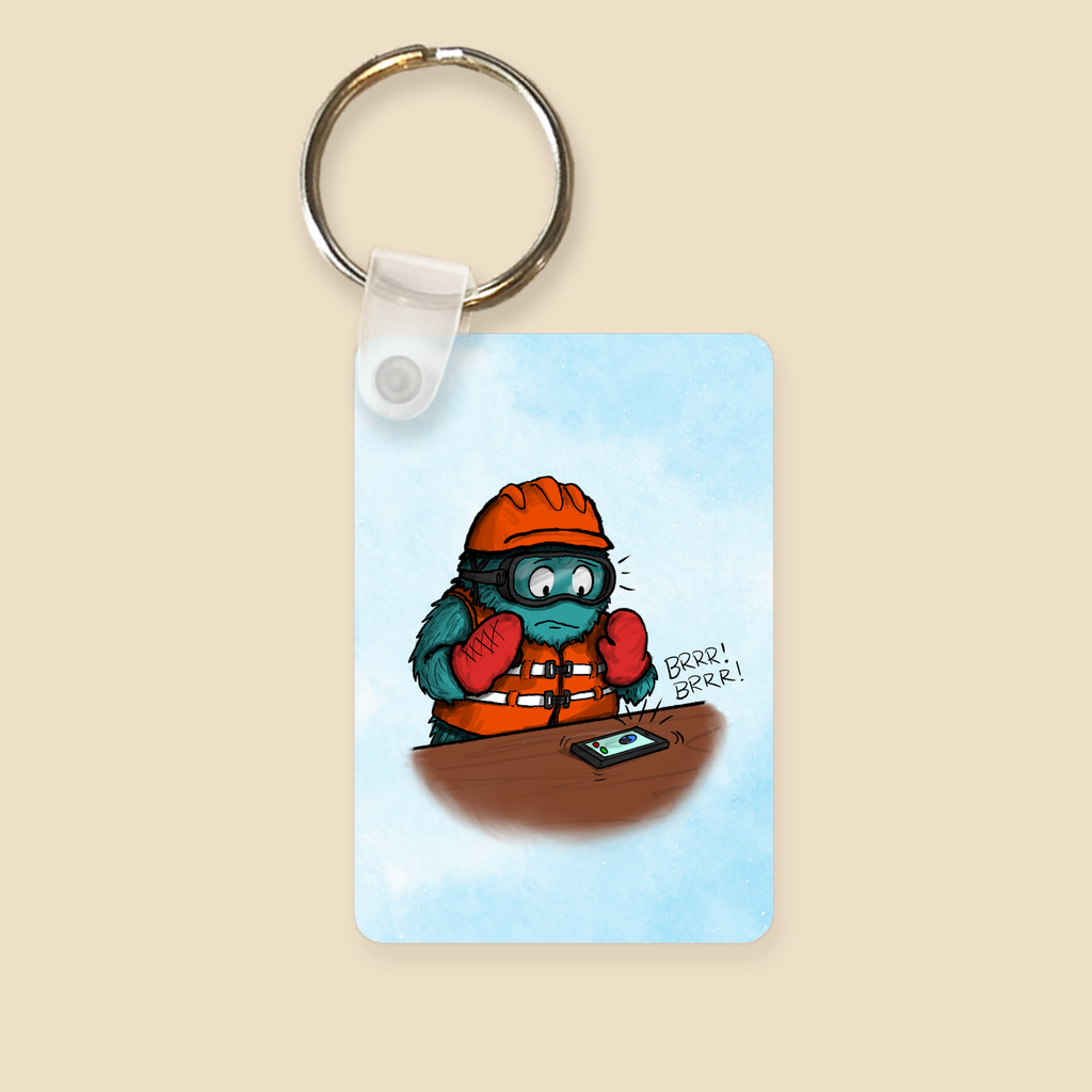 Keychain featuring a furry monster wearing lots of safety gear and panicking as an unexpected phone call comes in.