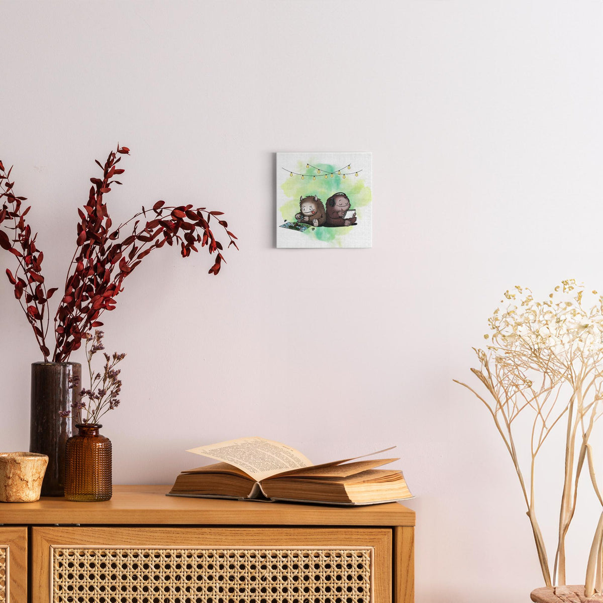 Canvas wrap featuring two cartoon creatures sitting back to back beneath string lights, one working on a puzzle and the other writing in a notebook, with a warm watercolor background.