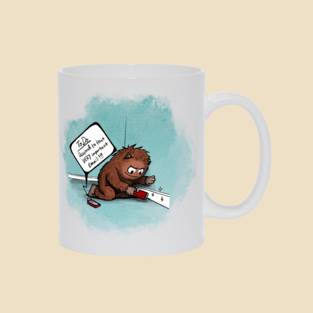 White mug featuring a brown furry monster sitting on the floor cleaning a baseboard while a phone reminds him to respond to an important email.
