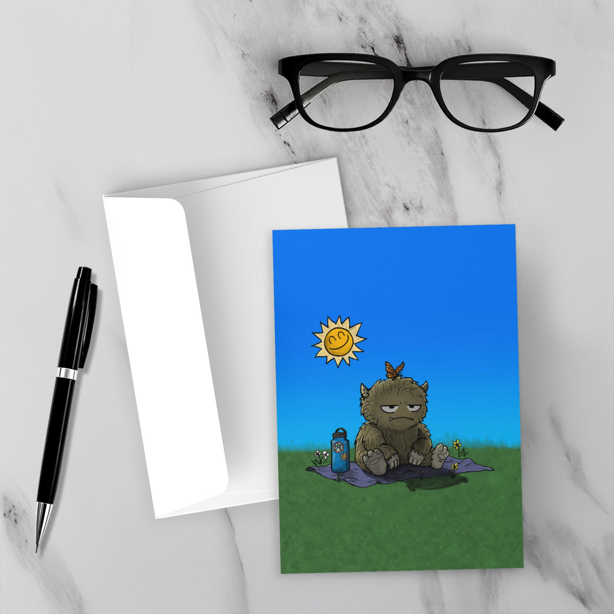 Greeting card featuring a furry monster sitting miserably in the sunshine while the cheerful world around it enjoys a beautiful day.