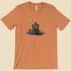 T-shirt featuring a furry monster sitting miserably in the sunshine while the cheerful world around it enjoys a beautiful day.