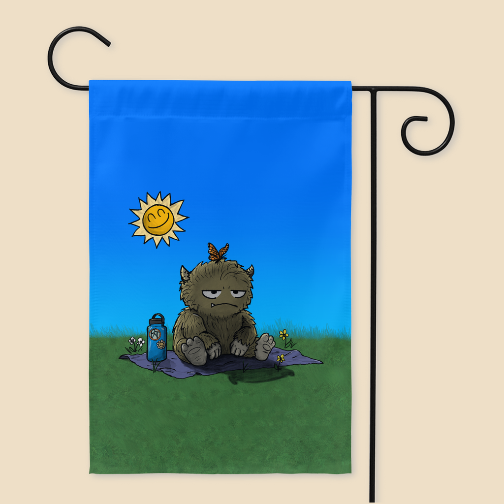 Yard flag featuring a furry monster sitting miserably in the sunshine while the cheerful world around it enjoys a beautiful day.