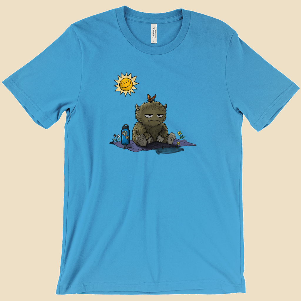 T-shirt featuring a furry monster sitting miserably in the sunshine while the cheerful world around it enjoys a beautiful day.