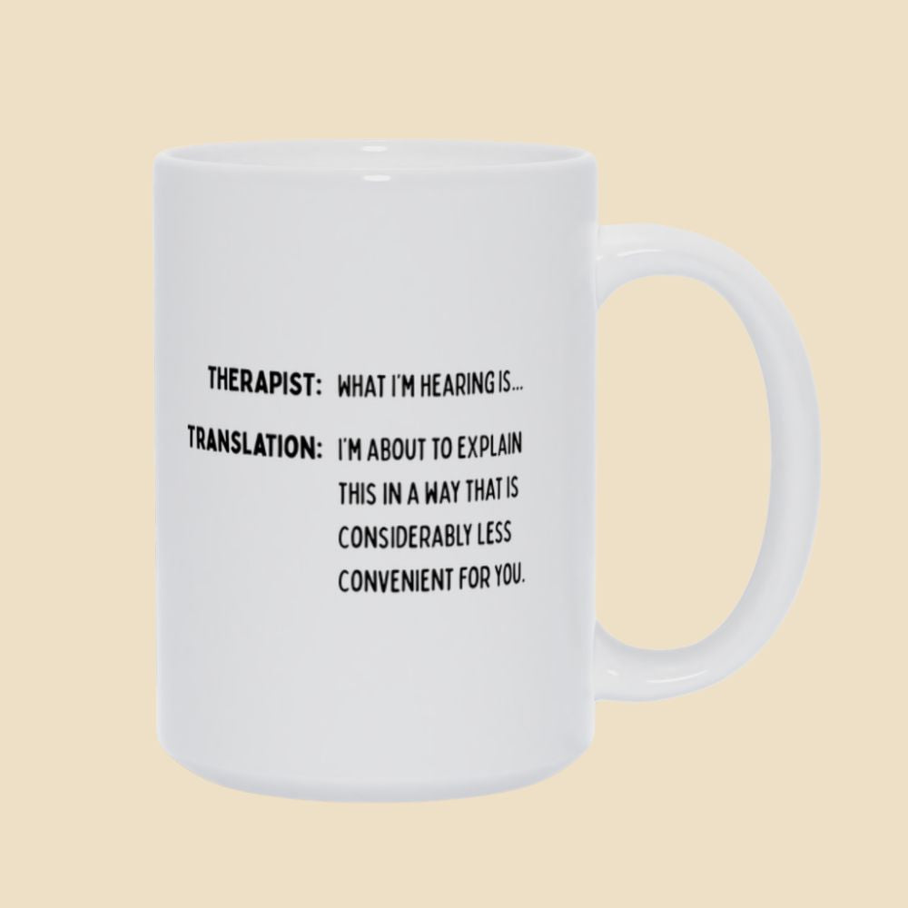 White mug with black text reading “Therapist: What I’m hearing is… Translation: I’m about to explain this in a way that is considerably less convenient for you.”