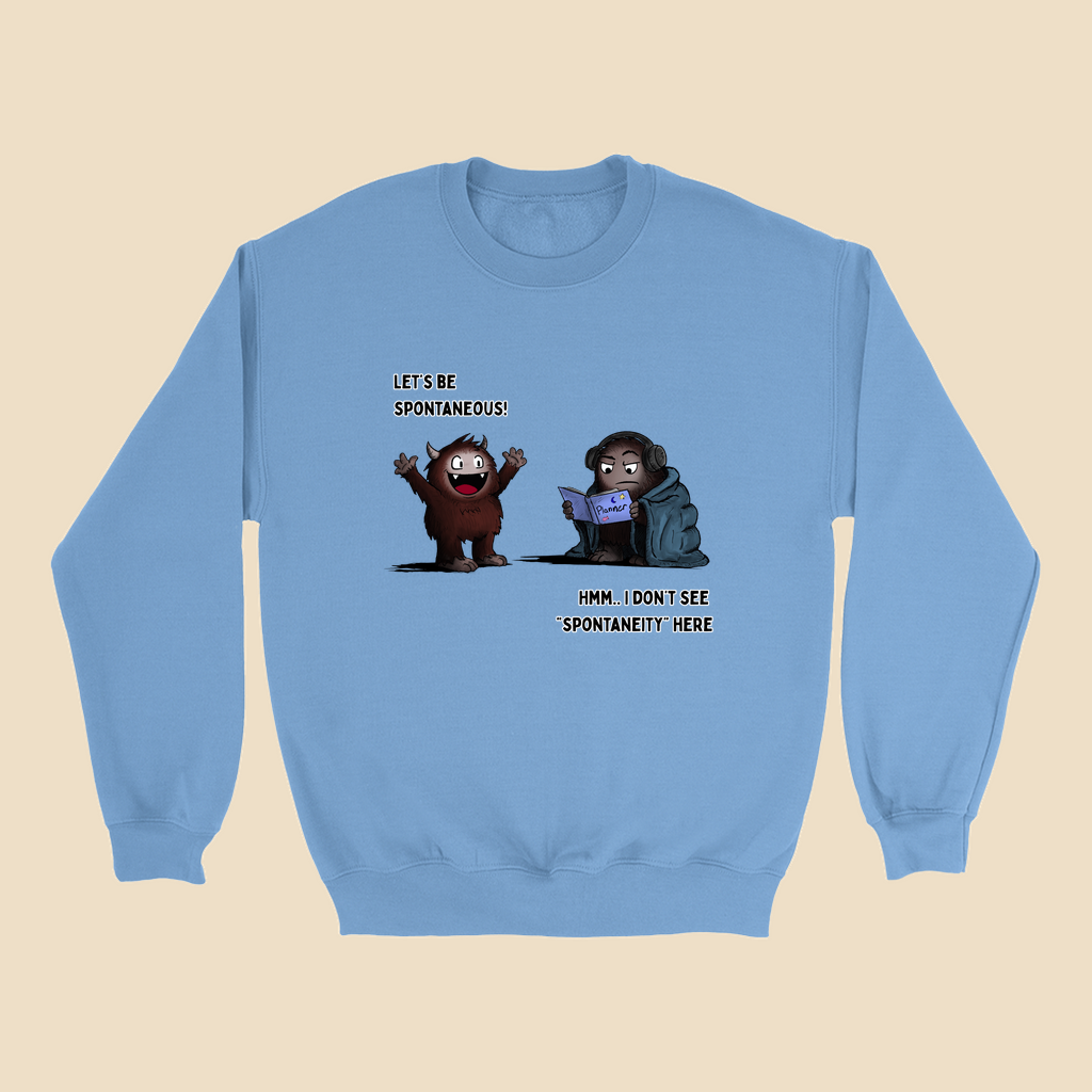 Sweatshirt featuring two cartoon creatures, one saying “Let’s be spontaneous!” while the other checks a planner and replies, “Hmm... I don’t see ‘spontaneity’ here.”