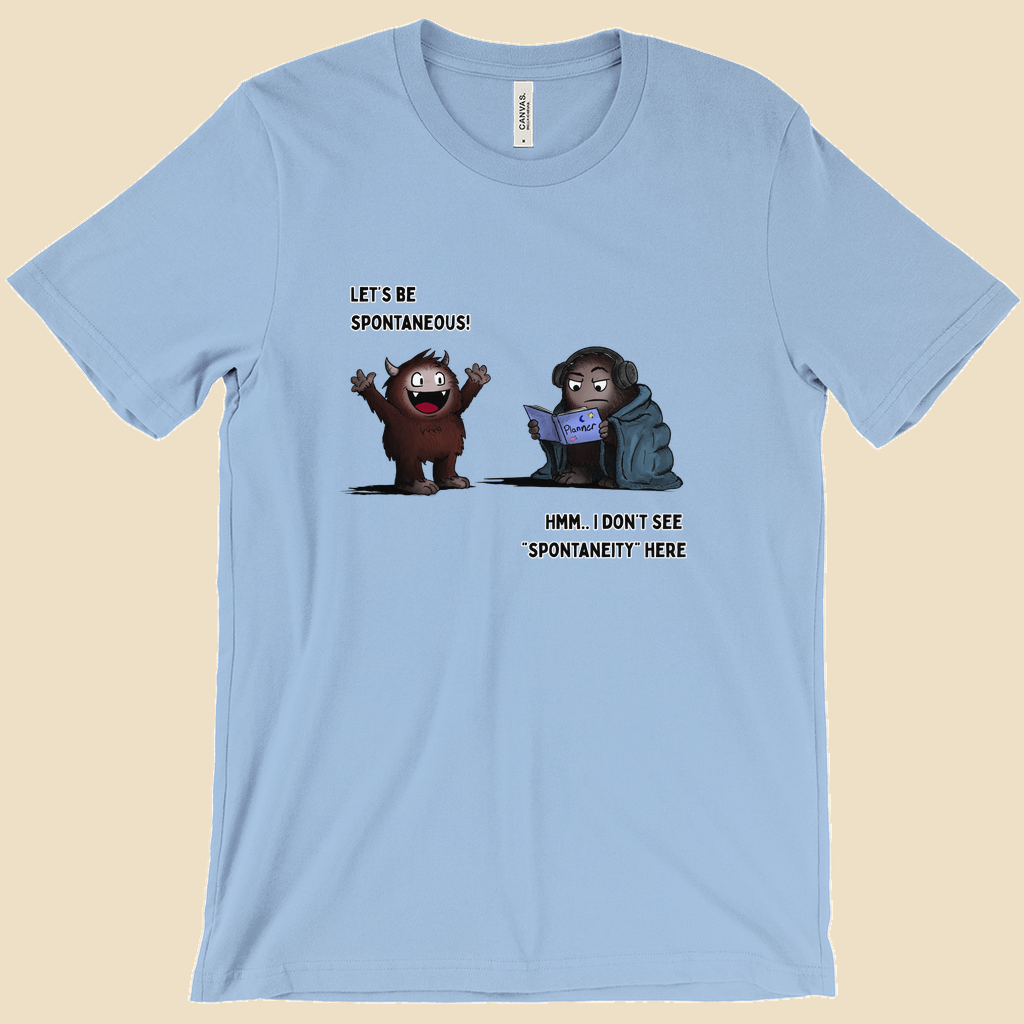 T-shirt featuring two cartoon creatures, one saying “Let’s be spontaneous!” while the other checks a planner and replies, “Hmm... I don’t see ‘spontaneity’ here.”