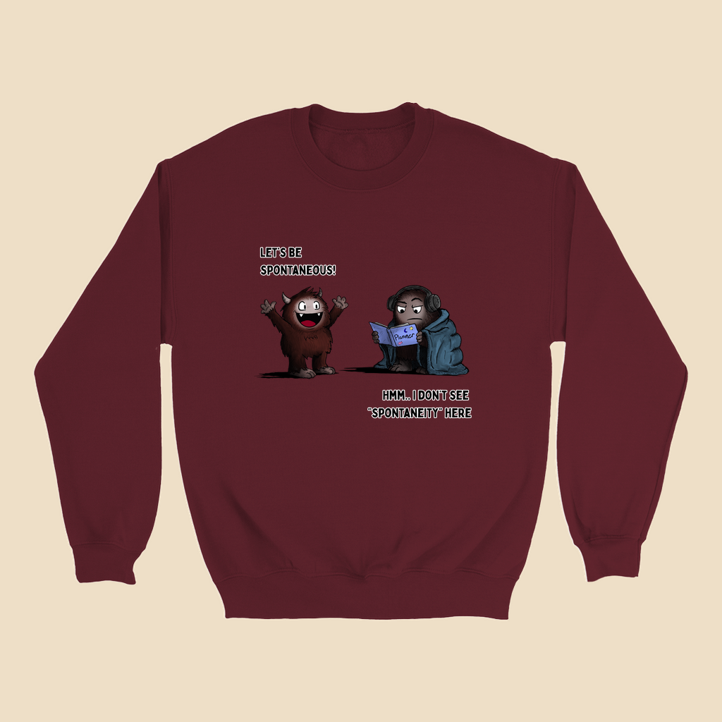 Sweatshirt featuring two cartoon creatures, one saying “Let’s be spontaneous!” while the other checks a planner and replies, “Hmm... I don’t see ‘spontaneity’ here.”